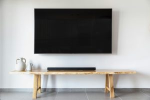 A professional installing a TV wall mount in a modern Nairobi living room.